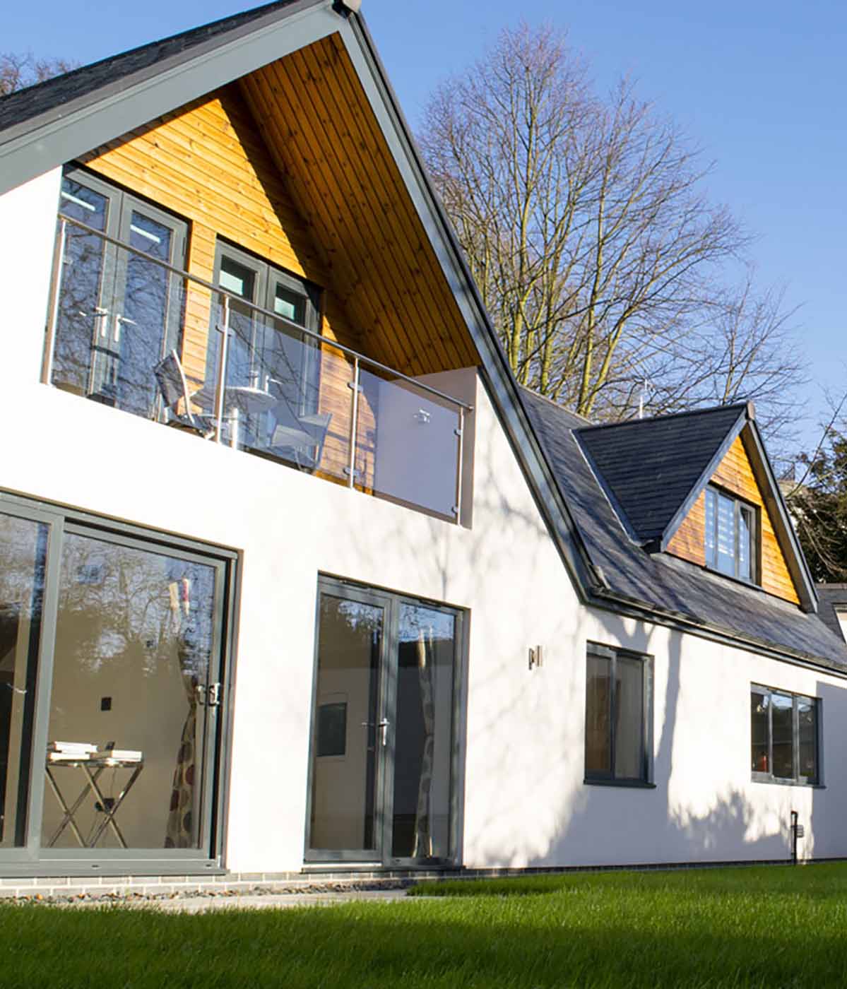 Wide shot showing the frontage of a large modern residential bungalow and it's rendered walls.